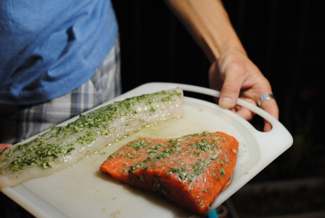 The Grillmaster displaying cuts of true cod (low-amine) and salmon (high-amine) marinating in garlic, dill, and ascorbic acid.