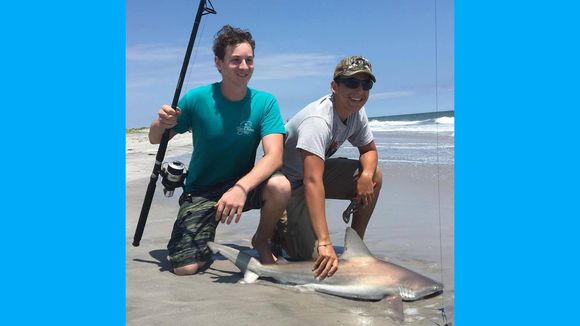 Chris Mears and Ethan Bruzzese with a brown shark landed from the Brigantine surf. (Photo: RipTide Bait and Tackle, Brigantine NJ)